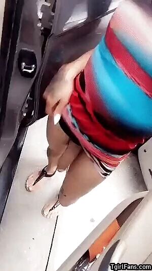 Ts Kitty Hung showing her cock off between 2 cars