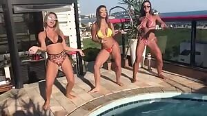 Happy girls dancing by the swimming pool