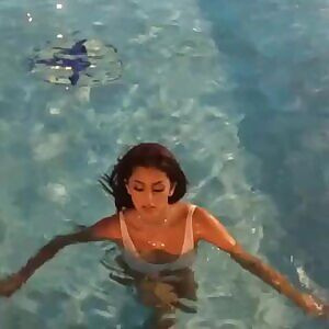 coming out of the pool in a sheer swimsuit