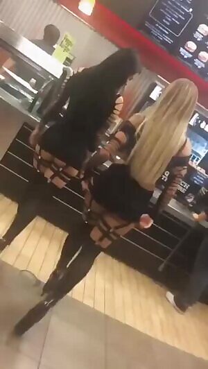 Two whores lift up their skirts and shake their asses in the line at Burger King