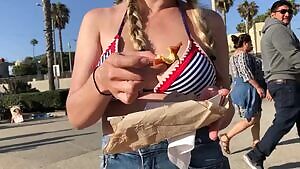 Enjoying a corn dog by the beach.