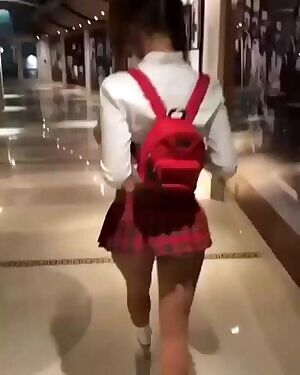 Cute girl in school skirt is walking in the stores